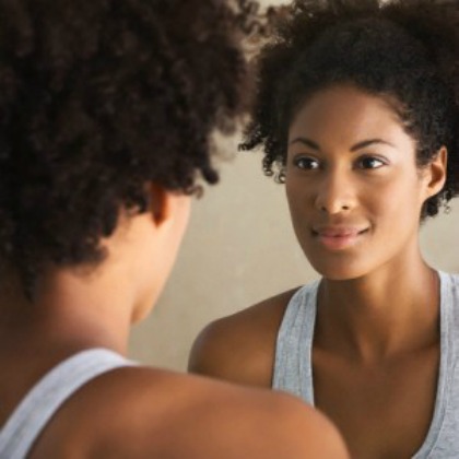 black woman looking in the mirror