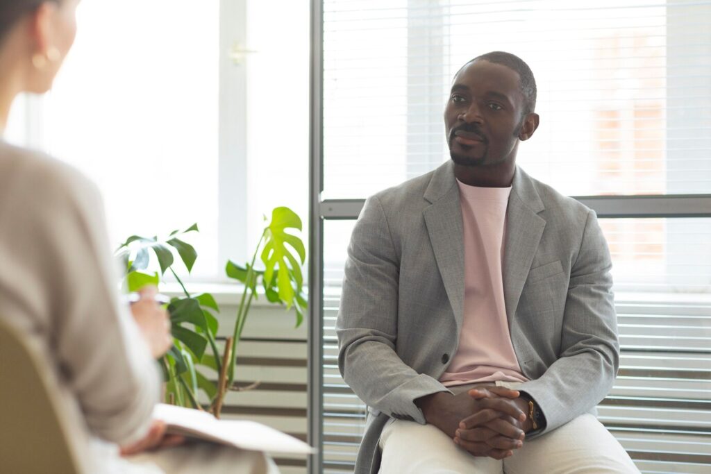 man being interviewed indoors by journalist 23 2149029360