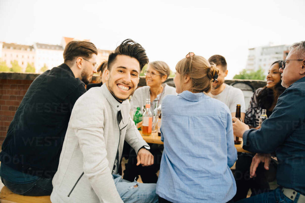 portrait of happy man sitting with friends and enjoying at social gathering MASF16522