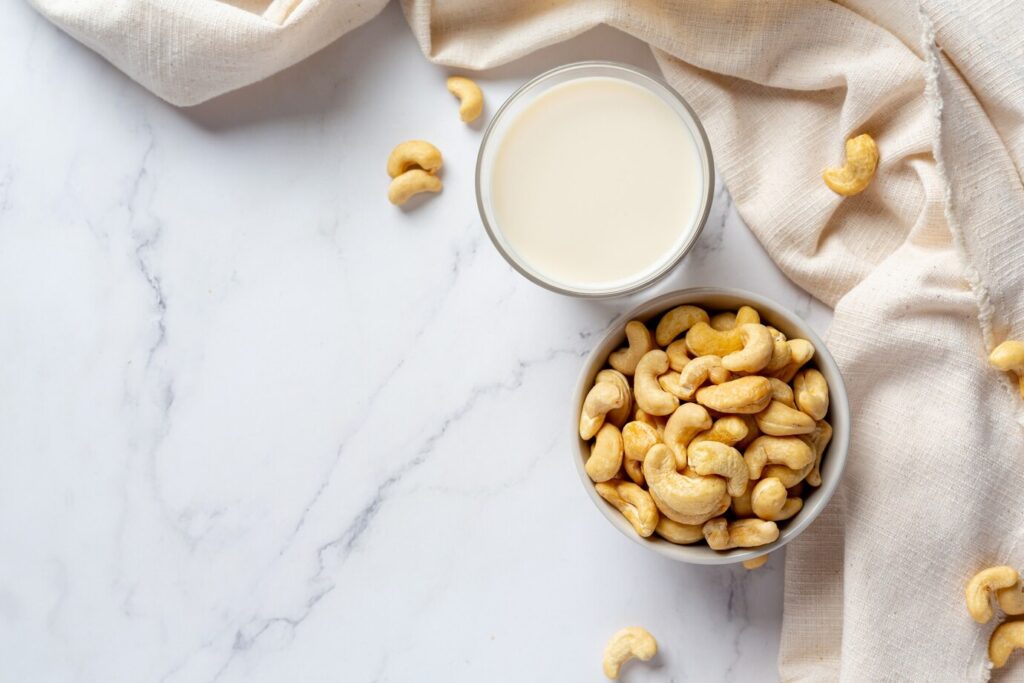 vegan cashew milk glass with cashews nuts marble background 1150 45375